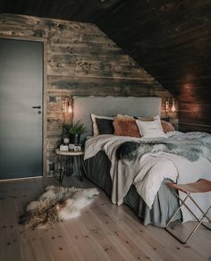 a bedroom with wooden walls and a bed in the corner, next to a chair