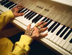 a person with tattoos on their hands playing the piano