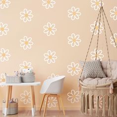 a room with a chair, table and flower wall decals on the wall behind it