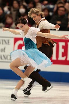 two people are skating on an ice rink