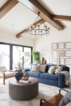 a living room with blue couches and pictures on the wall above it, along with other furniture