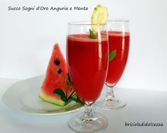 two glasses filled with watermelon juice on top of a white plate