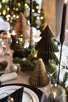 a table set for christmas with candles and ornaments