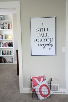 a room with a book shelf, bookshelf and a poster on the wall that says i still fall for you everyday