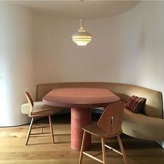 a living room with a couch, table and chair next to a round light fixture