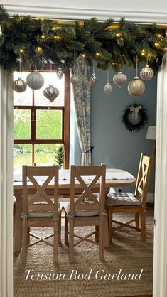 a dining room table with christmas decorations on the top and lights hanging from the ceiling