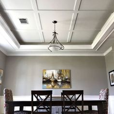 a dinning room table with chairs and a chandelier hanging from the ceiling