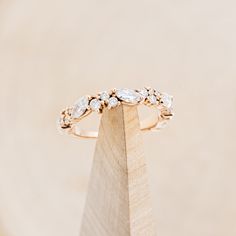 a diamond ring sitting on top of a wooden stand