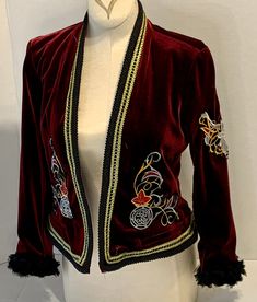 this Up - Cycled Mod Style Velvet Jacket is made from Burgundy Velvet.   The embroidery is gold burgundy and silver in an elven motif.   Very cool looking jacket with jeans or dresses, it can be dressed up or down, go boho or fancy! The embroidery is stitched on the front, back and one sleeve.   The sleeves are embellished with a black chiffon floral trim. The neckline and hem are trimmed in black and gold.  The sleeves are 3/4.  This is an old Navy size XS blazer style jacket .  It measures 34 in the bust and is 18.5 inches long. Traditional Fitted Embroidered Blazer, Festive Fitted Outerwear With Floral Embroidery, Festive Fitted Floral Embroidery Outerwear, Fitted Embroidered Festive Blazer, Festive Fitted Embroidered Blazer, Fitted Winter Festive Blazer, Traditional Fitted Red Blazer, Festive Embroidered Blazer For Fall, Traditional Fitted Embellished Outerwear