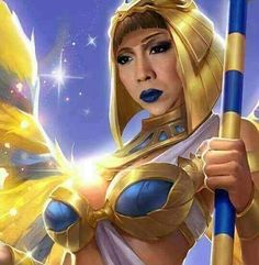 a woman dressed as an egyptian goddess holding a staff and wearing blue makeup with gold wings