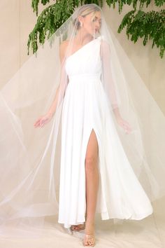 This all white dress features a one-shoulder neckline with a non-slip rubber strip, a side zipper, an optional self-tie belt, a flowy skirt, and a slit up the leg. Goddess Of The Night, White Maxi Dress, Red Dress Boutique, White Maxi, The Goddess, Flowy Skirt, White Maxi Dresses, Belt Tying, Strapless Bra