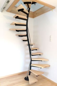 a spiral staircase in an empty room with wood floors