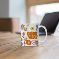 a coffee mug with the words good vibes on it sitting on a wooden table