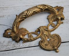 an ornate gold metal object on a white wooden surface