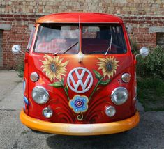 an orange vw bus with sunflowers painted on it