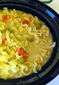 a crock pot filled with chicken noodle soup