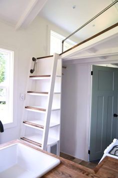 a kitchen with a sink and ladder in it