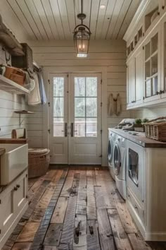 a rustic kitchen with wood floors and white cabinets