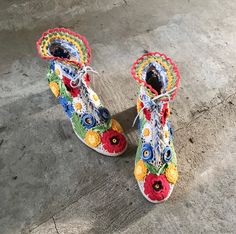 a pair of colorful shoes sitting on top of a cement floor next to each other