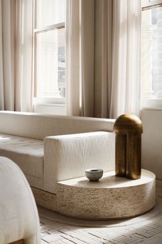 a white couch sitting next to a window in a living room