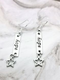 Cute handmade Hope earrings with a little star attached to the bottom. For those hoping to achieve their dreams or a gift to those that need that little push to believe they can achieve anything, have faith in that hope. Total length of earring is approximately 5.6cm and the star is approximately 0.9cm wide at the widest points. Please allow for small measuring error. Both charms and findings are silver plated. Please contact me with any questions. Hope Earrings, Have Faith, Earrings Dangle, Star Earrings, Earrings Silver, Charm Earrings, Jewelry Earrings Dangle, Silver Plate, Silver Plated