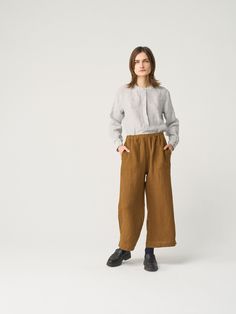 "Get comfortable and let it loose with these relaxed, slightly flared pants. Offered in heavy-weight linen. STYLE DETAILS * Relaxed fit (the pair in the photos is a bit big for the model, so Your true size will be a bit more snug but still comfortably loose) * Elastic waist * 2 side pockets and one patch pocket on the back * Slightly flared at the bottom * Cropped (ankle length) * Made from heavy-weight linen SIZES & COLORS IN THE PICTURES * Model is wearing size S/M in Toffee (Heavy) linen. Mod Linen Bottoms With Elastic Waistband For Fall, Fall Linen Bottoms With Elastic Waistband, Fall Wide Leg Linen Pants With Elastic Waistband, Spring Linen Culottes With Pockets, Linen Wide Leg Pants For Fall, High-waisted Wide Leg Linen Pants With Side Pockets, Relaxed Fit Wide Leg Culottes With Pockets, Fall Linen Wide Leg Pants, Linen Wide-leg Culottes For Work