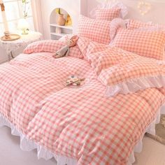 a pink and white checkered comforter set with ruffles on the bottom