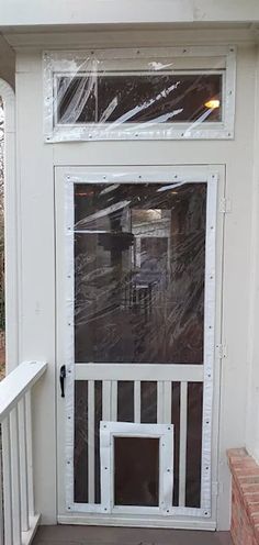 the front door is covered with plastic and has a dog door on it's side