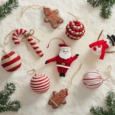 christmas ornaments are laid out on the snow and decorated with candy canes, gingerbread cookies, santa clause ornament