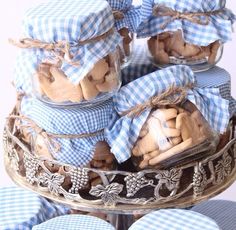 several jars filled with cookies sitting on top of a cake plate covered in blue gingham