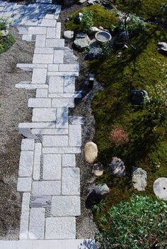 a stone path in the middle of a garden