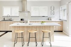 three stools are in front of the kitchen island