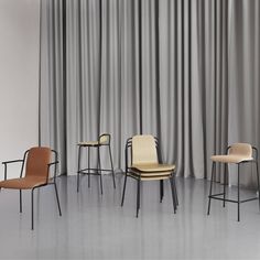 three chairs in front of a curtained wall