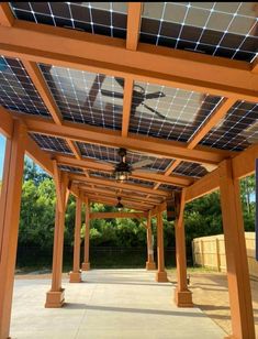 an outdoor covered patio with a ceiling fan and solar panels on the top of it