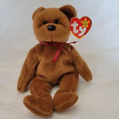 a brown teddy bear with a red ribbon around it's neck sitting on a white background