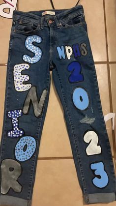 a pair of jeans with letters painted on them