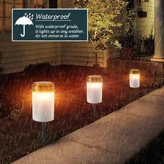 three solar powered lights on the side of a house with an umbrella sign in the background