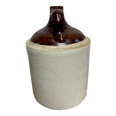 a white and brown ceramic vase with a horse head on the top, against a white background