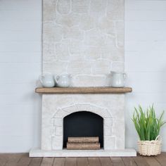 a living room with a fireplace and potted plants