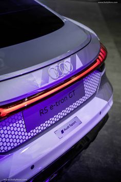 the rear end of an electric car with purple lights on it's taillights