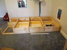 an unfinished bed frame in the corner of a room with carpeted floor and walls