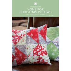 two christmas pillows sitting on top of a leather couch next to a chair with the words home for christmas pillows