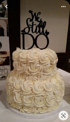 a wedding cake with white frosting and black lettering on top that says we still do