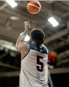 a basketball player is about to dunk the ball into the air with his right hand