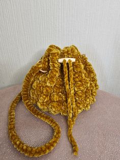 a yellow purse sitting on top of a pillow