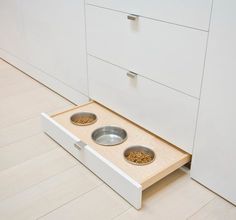 an open drawer with two bowls on the bottom and one bowl in the middle that is empty