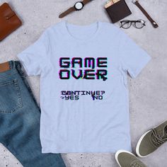 This nostalgic game over design is a great retro design or a great gift for the old school gamer in your life! This t-shirt is everything you've dreamed of and more. It feels soft and lightweight, with the right amount of stretch. It's comfortable and flattering for all.  * 100% combed and ring-spun cotton (Heather colors contain polyester) * Ash color is 99% combed and ring-spun cotton, 1% polyester * Heather colors are 52% combed and ring-spun cotton, 48% polyester * Athletic and Black Heather Gaming Event Crew Neck T-shirt With Letter Print, Casual Tops With Letter Print For Gaming Events, Casual Top With Letter Print For Gaming Events, Casual Letter Print Top For Gaming Events, Gamer Tops With Letter Print, Crew Neck T-shirt For Gaming Events With Letter Print, Crew Neck T-shirt With Letter Print For Gaming Events, Cotton T-shirt With Letter Print For Gaming Events, Crew Neck Letter Print T-shirt For Gaming Events