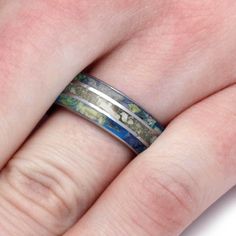 a close up of a person's hand with a wedding ring on their finger