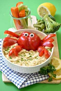 a crab in a bowl with tomatoes and broccoli