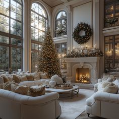 a living room filled with white furniture and a christmas tree in the middle of it